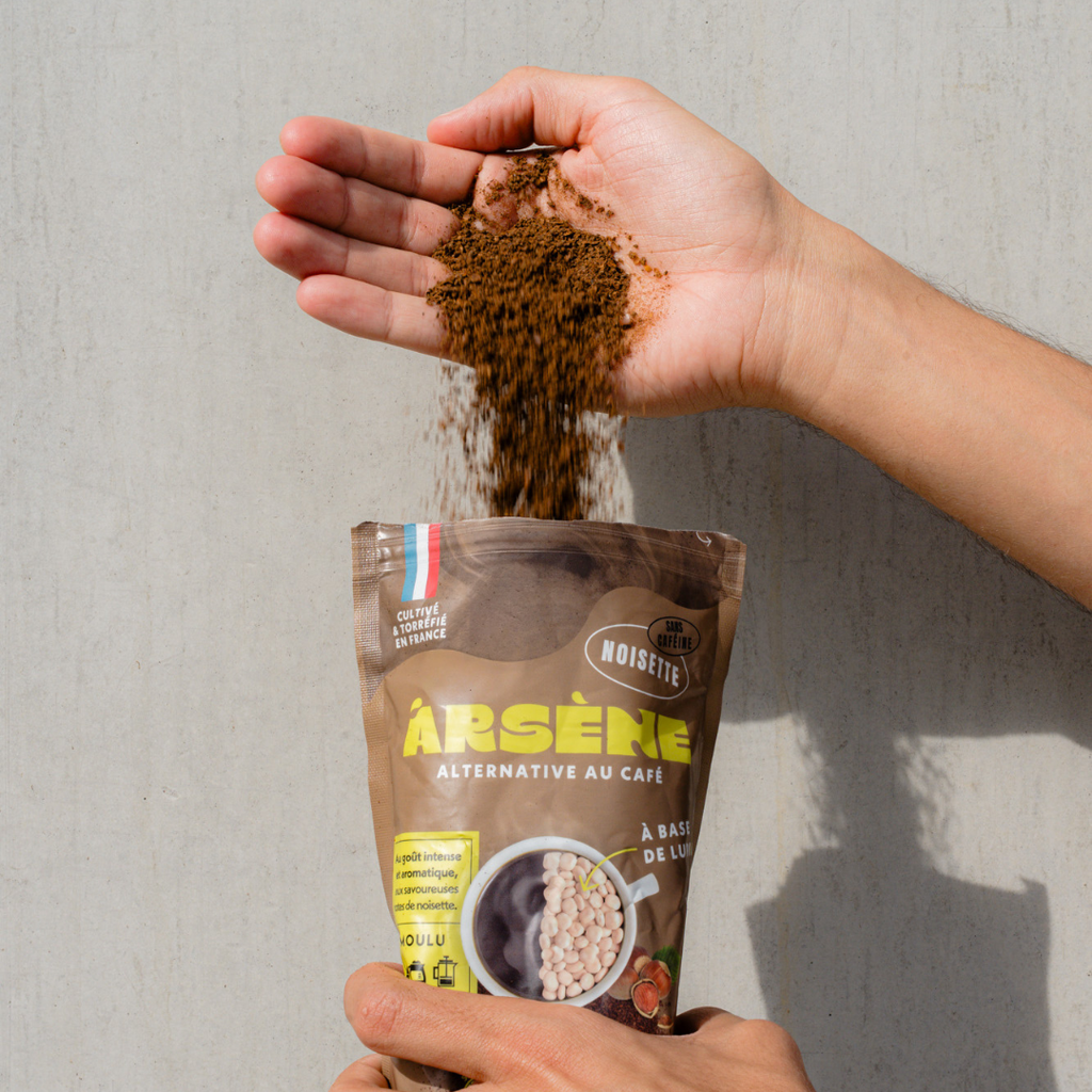 Mains versant la poudre d'Arsène Noisette depuis le paquet, alternative au café torréfiée en France